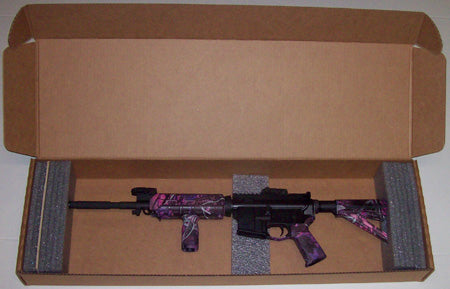 A rifle in a cardboard box with gray foam padding