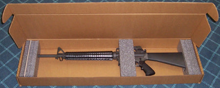 A rifle in a cardboard box on a blue checkered background