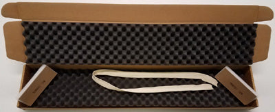 Cardboard box with black foam lining and a white strap inside