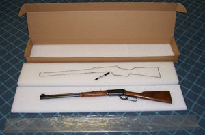 Wooden rifle in a box on a blue surface
