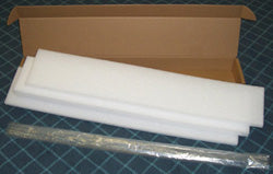 Packaging materials including foam and a cardboard box on a grid background