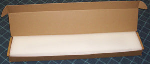 Open cardboard box with white foam on a checkered floor.
